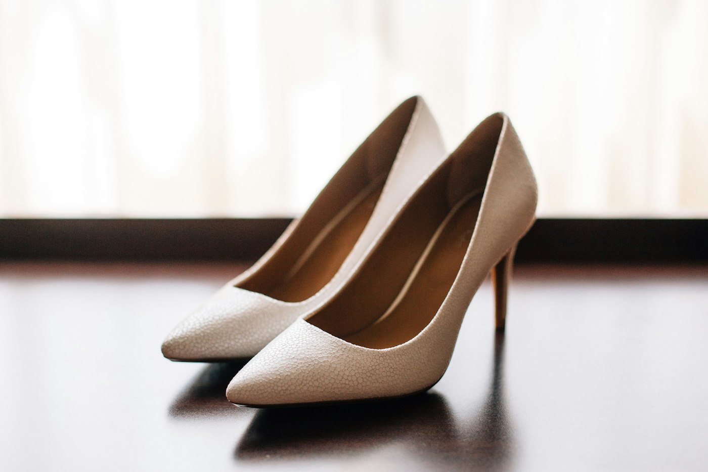 Ivory pointed pumps on a dark table